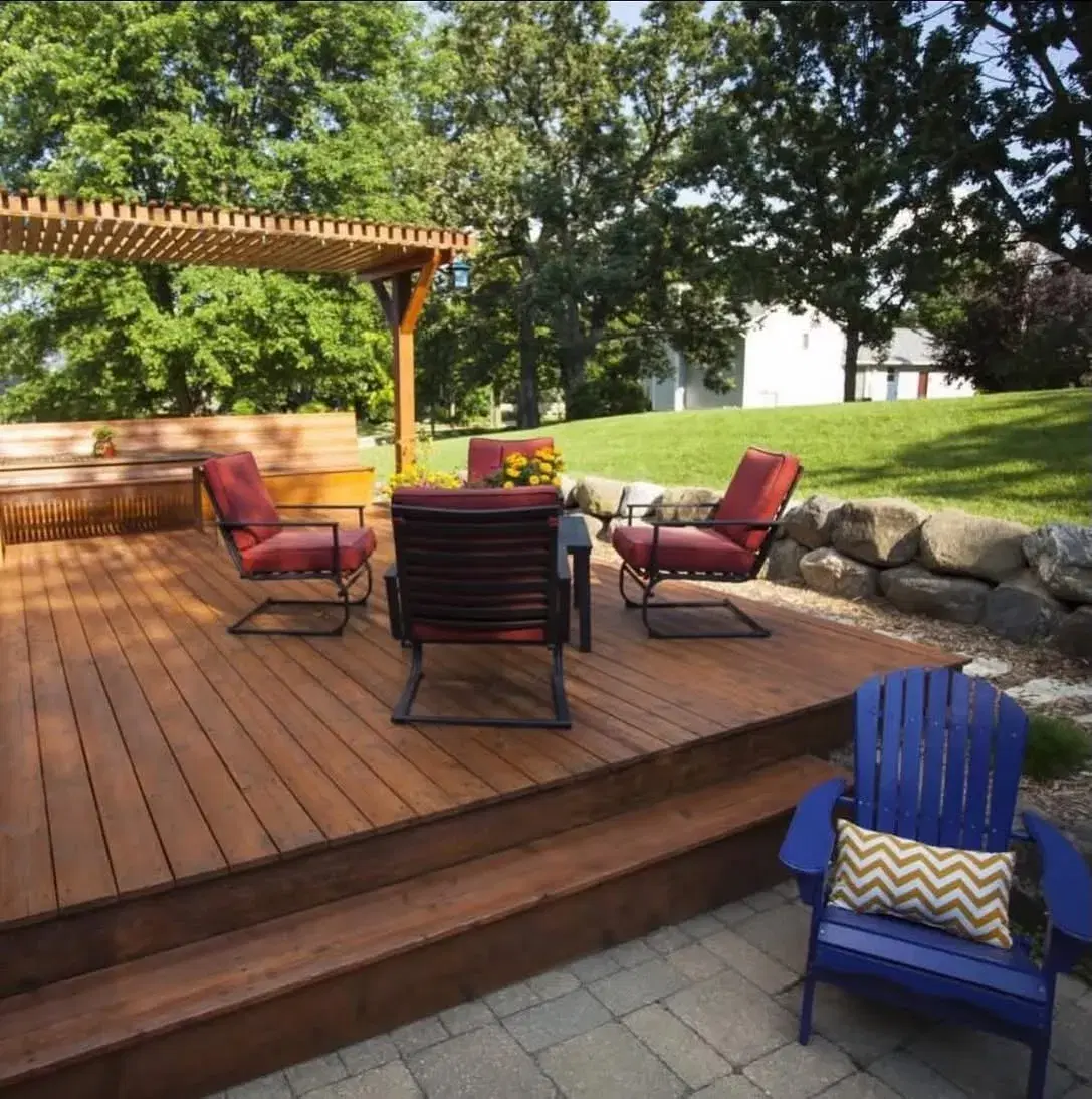 Cedar deck with a pergola and lounge seating in a landscaped backyard