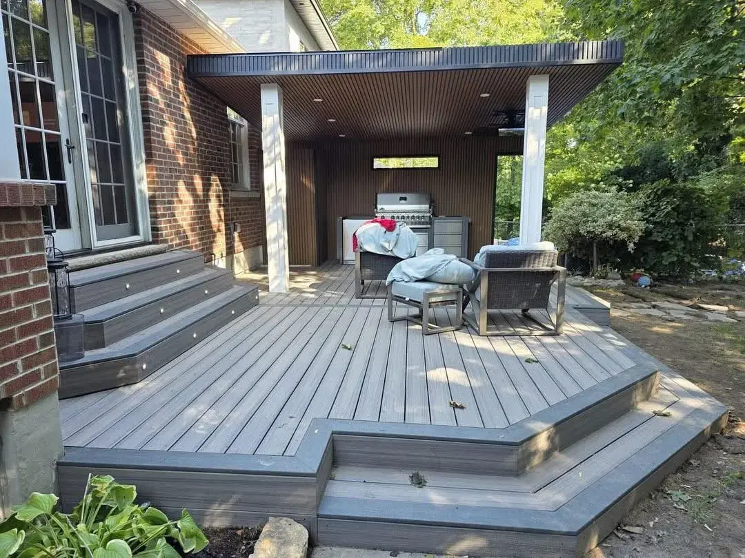 Multi-tier grey composite deck with a covered pavilion and built-in grill